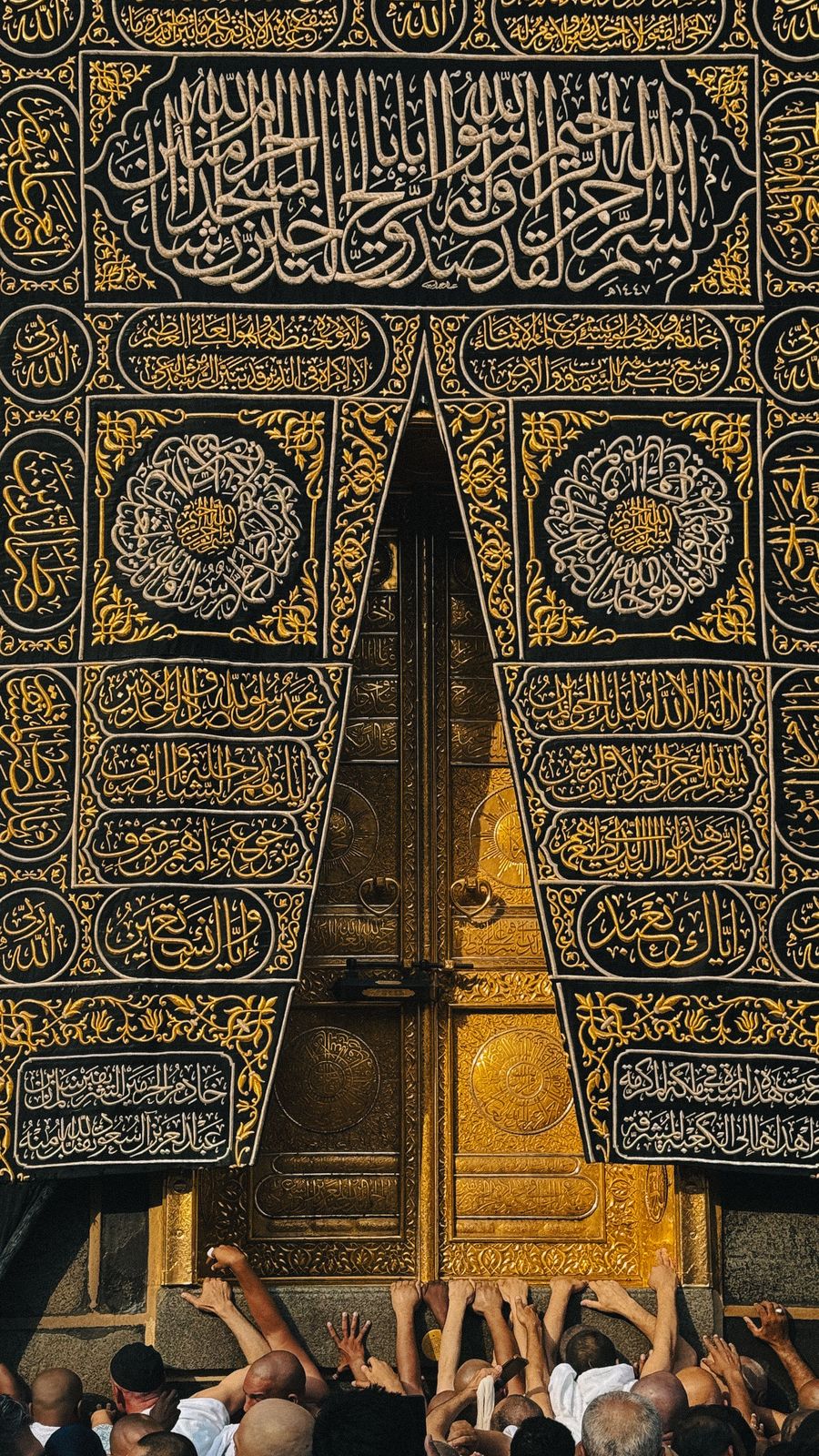 Pilgrims reaching towards the door of the Kaaba, Makkah